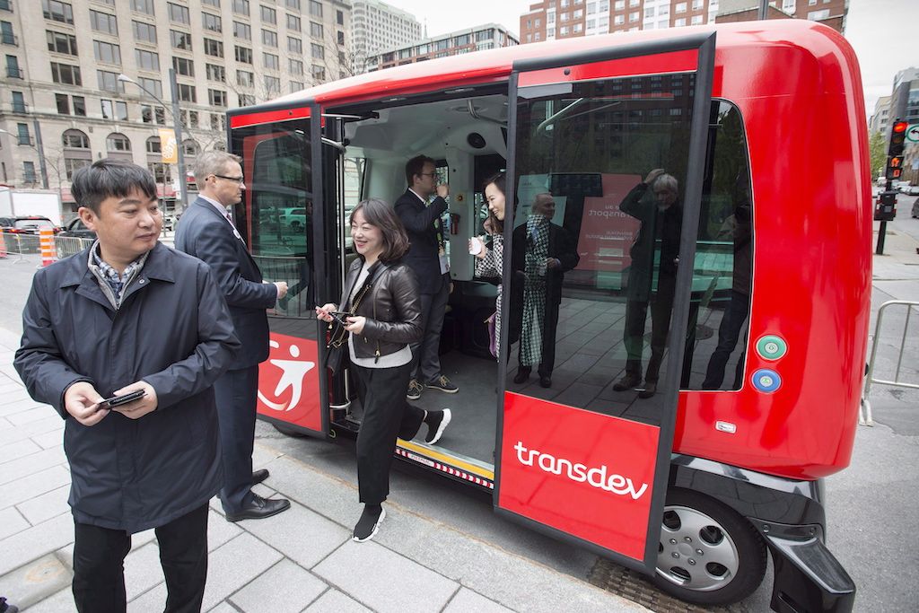 Passengers disembark from an autonomous bus after taking a short ride in Montreal in May 2017. The driverless vehicle was being featured at a transportation conference..