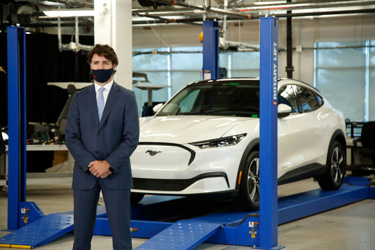 Prime Minister Justin Trudeau stands in front of a Ford Mach-5 electric vehicle at the Ford Connectivity and Innovation Centre in Ottawa in October 2020.
