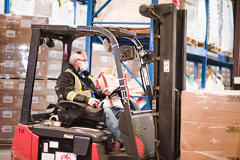 A worker moves cases of N95 respirators at 3M’s Brockville, Ont. plant.