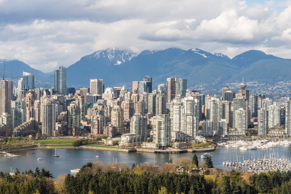 Buildings stretch across Vancouver’s skyline, framed by snow-capped peaks.