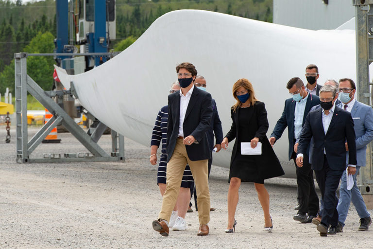 Prime Minister Justin Trudeau (left), GE Canada president Heather Chalmers and Innovation Minister François-Philippe Champagne (right) walk past a turbine blade at an LM Wind Power facility in Gaspe, Que., in July 2021.