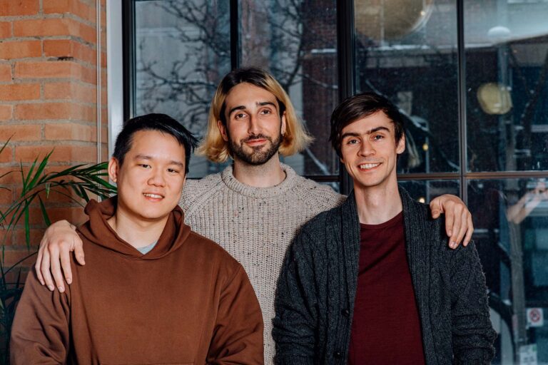 A photo of Cohere co-founders, Ivan Zhang, Aidan Gomez, and Nick Frosst, posing.