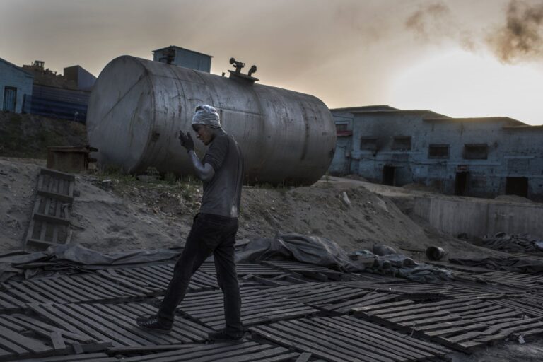 A graphite worker is seen walking across the Jin Yang graphite factory.