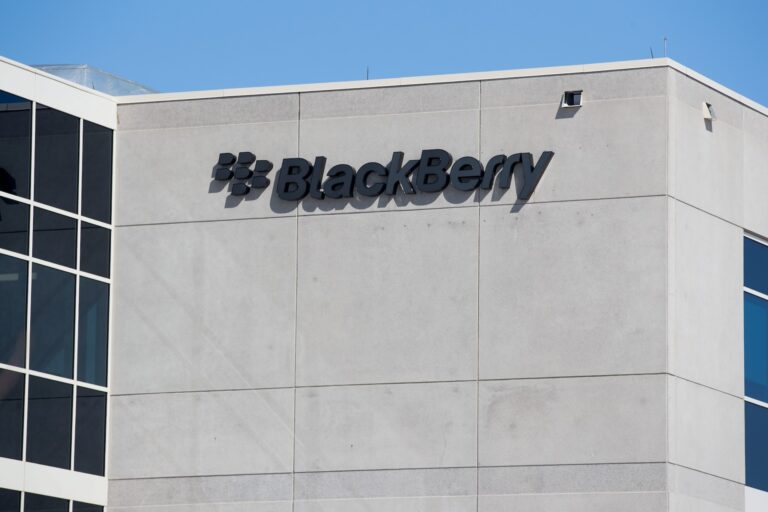 The BlackBerry logo, consisting of the BlackBerry emblem design and its name, on the top of a building.