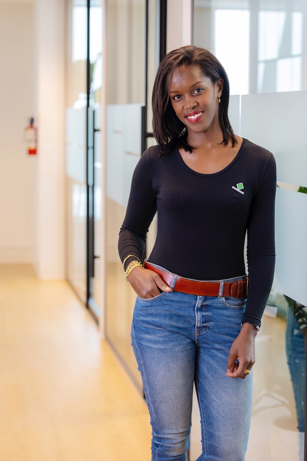 Insilico president Petrina Kamya is seen standing, with her right hand in the pocket. She is wearing a black T-shirt paired with blue pants. Caption: Petrina Kamya, president of Insilico Canada.