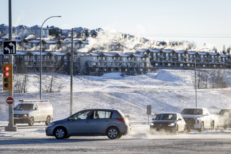 Cars drive in the foreground as houses are seen steaming in the background amid the province’s sudden cold snap over the weekend of Jan. 13.