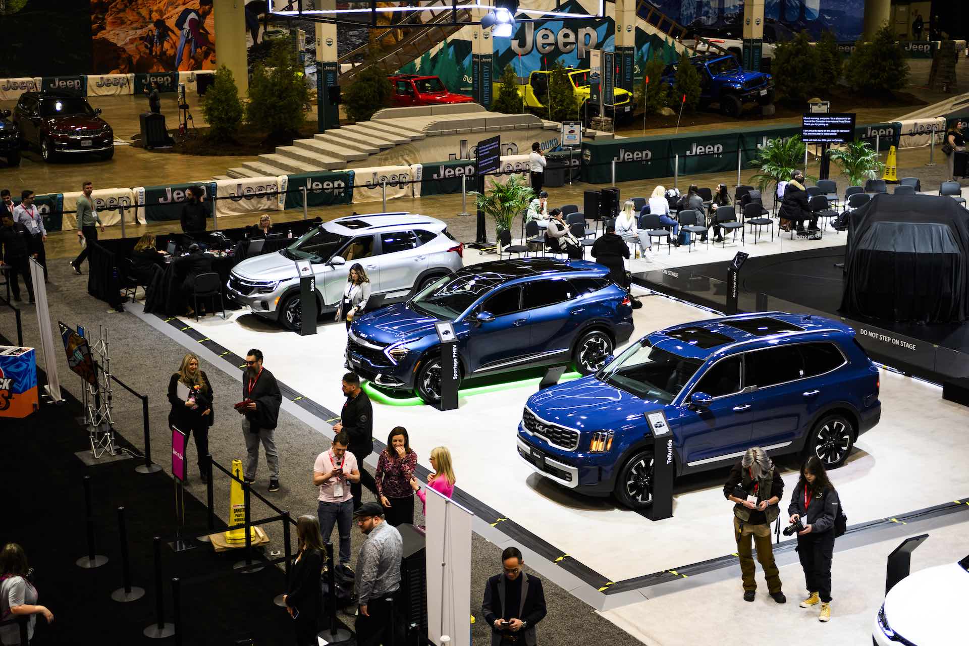 Three SUV’s lined up on a showroom floor. The first is white, and the next two are blue.
