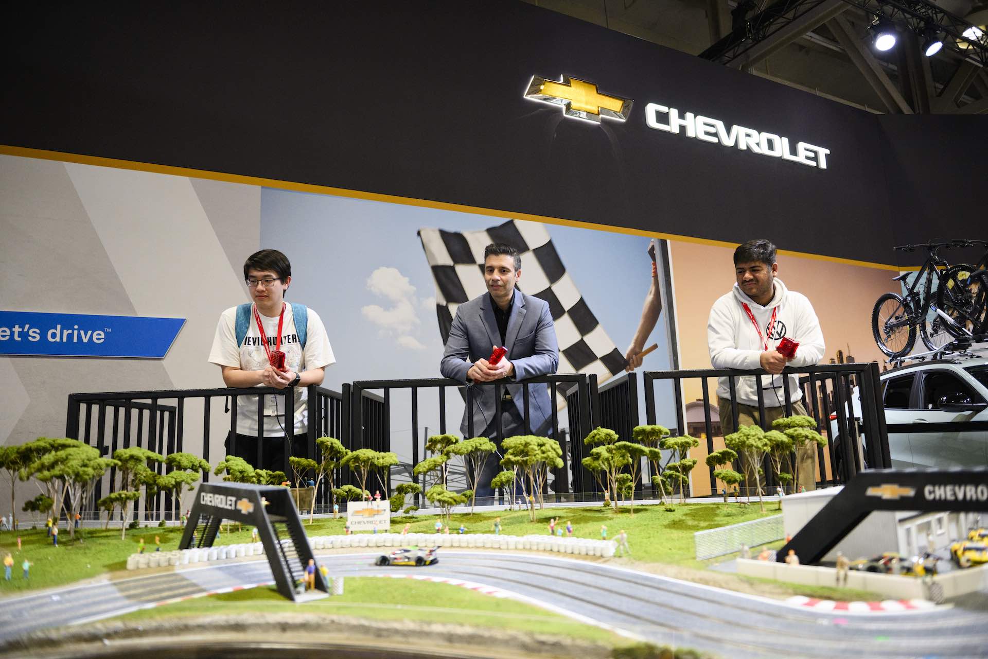GM Canada President Kristian Aquilina plays a radio controlled race car course with two other men at the Toronto Metro Convention Centre.