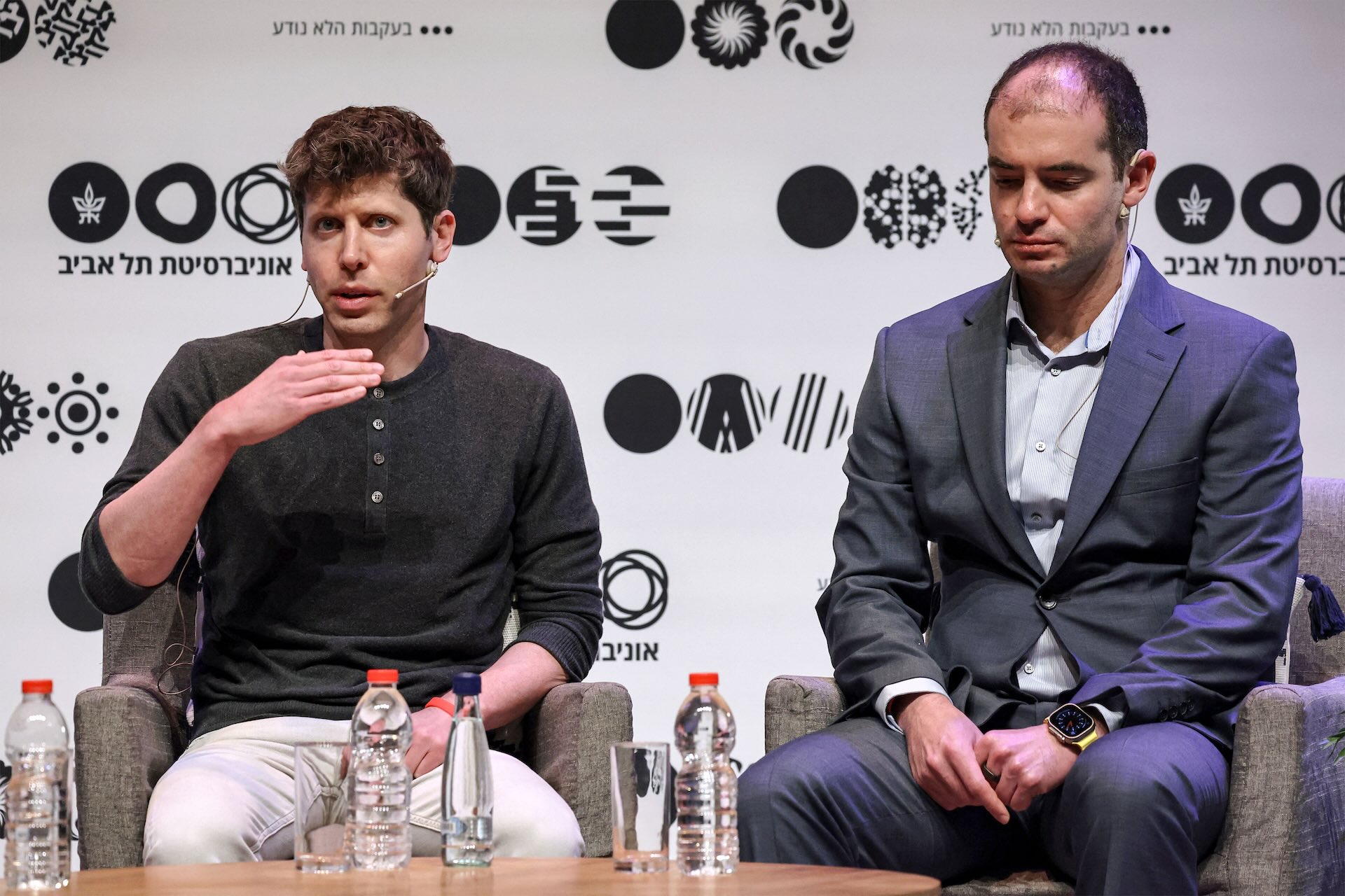 OpenAI founder and CEO Sam Altman in a black crewneck, sitting next to chief scientist Ilya Sutskever, suited up, on right.