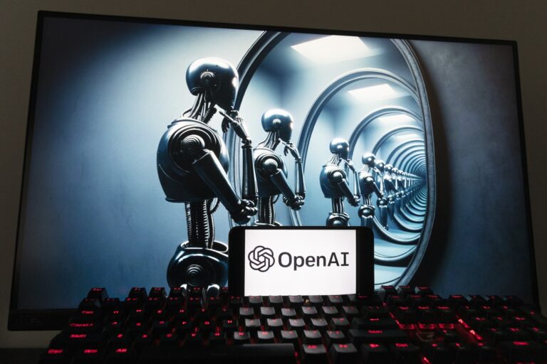 The OpenAI logo displayed on a cellphone, in front of an image on a computer screen generated by ChatGPT's DALL·E text-to-image model.