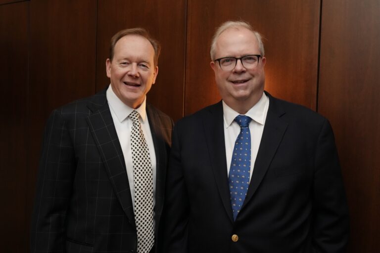 Ontario Securities Commission board chair Kevan Cowan, left, and chief executive officer Grant Vingoe standing next to each other and posing.