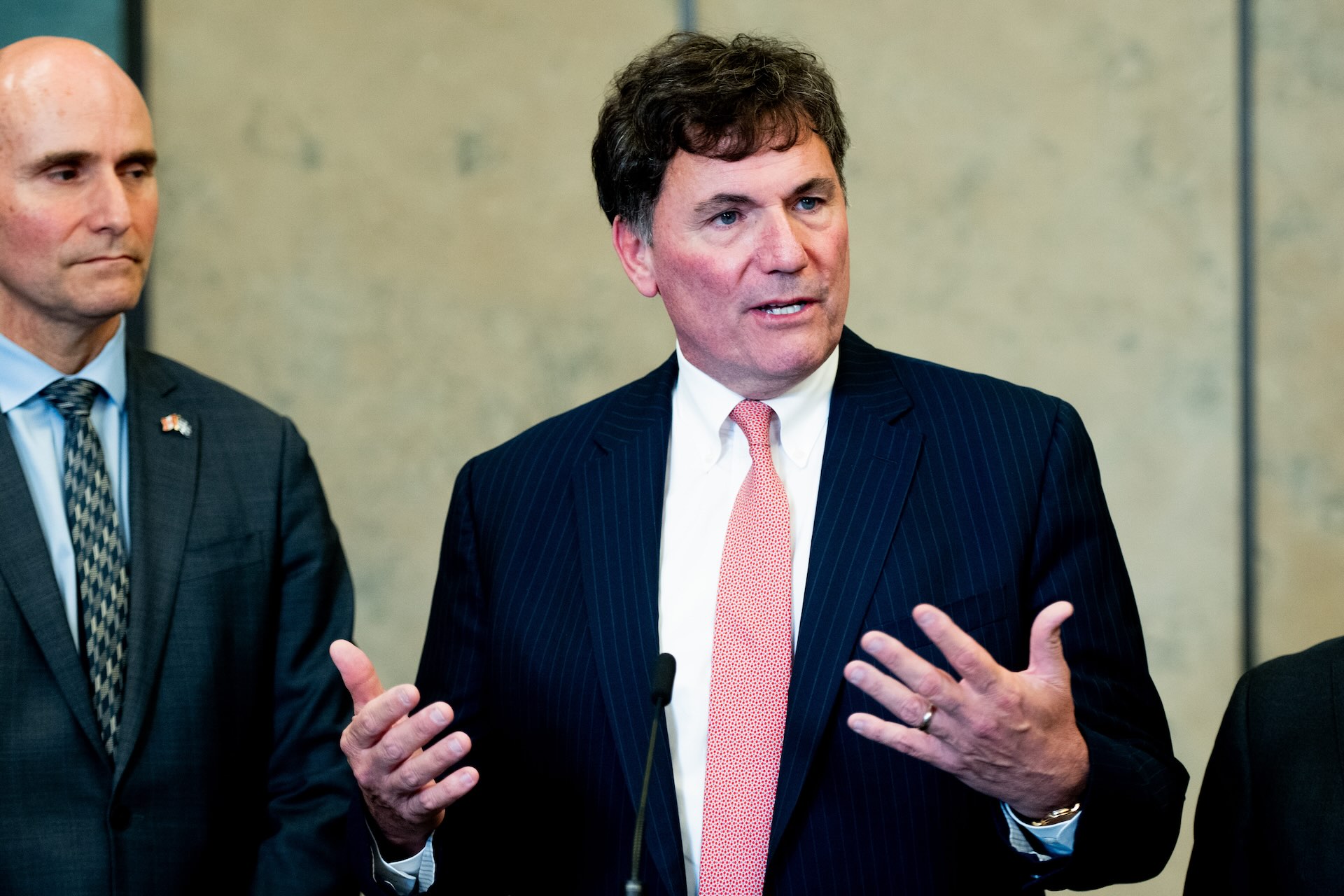 Public Safety Minister Dominic LeBlanc in a suit, speaking and gesturing with both hands. Procurement Minister Jean-Yves Duclos is standing next to him.