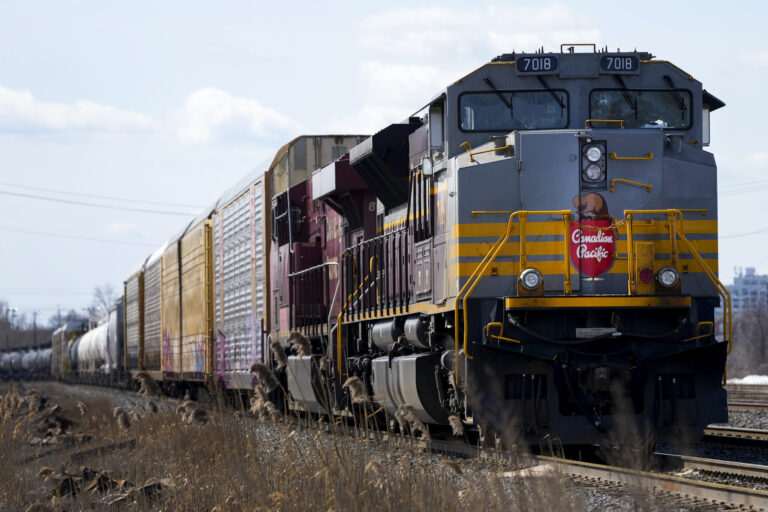 A shot of a locomotive with cars attached; the engine's nose is emblazoned with a retro-looking logo featuring the name "Canadian Pacific" and a beaver at the top.