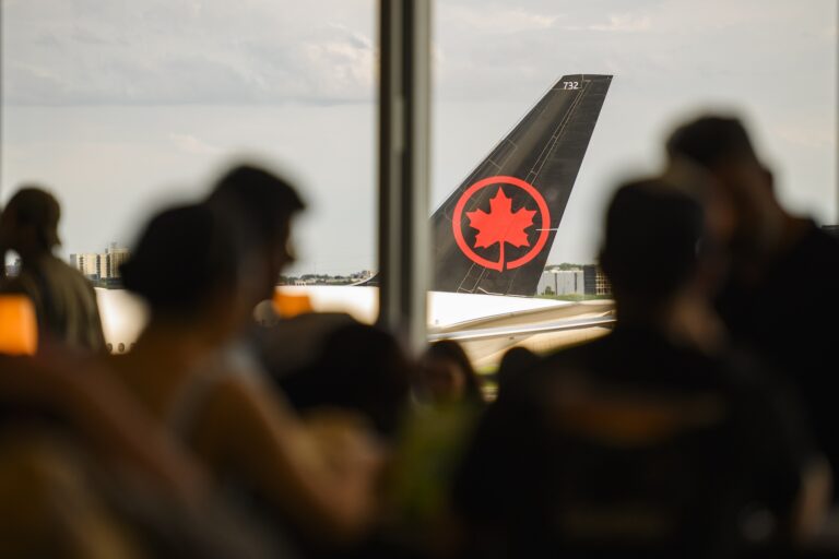 The tail of an Air Canada plane is seen through the window of a seating area at Toronto’s Pearson airport.