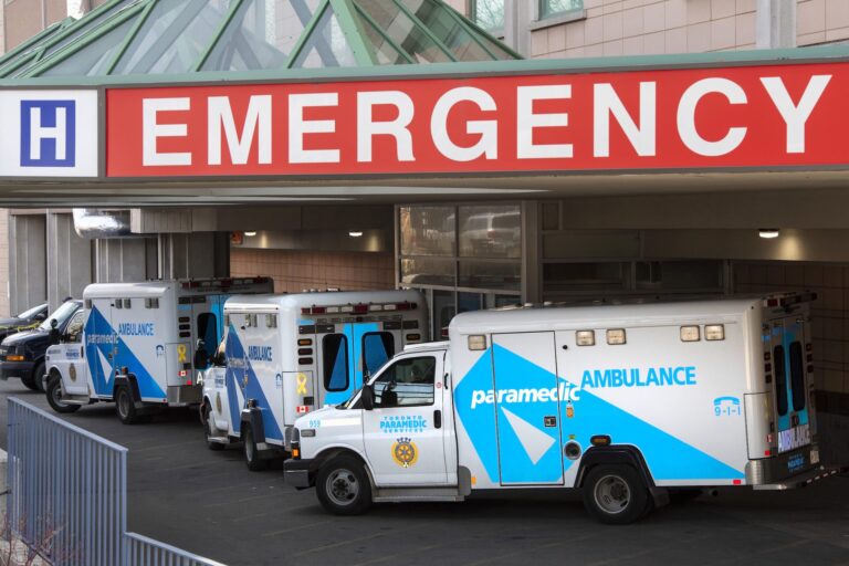 A line of ambulances outside a hospital.