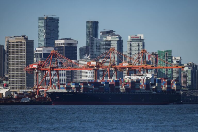 A container ship docked under gantry cranes in Vancouver.