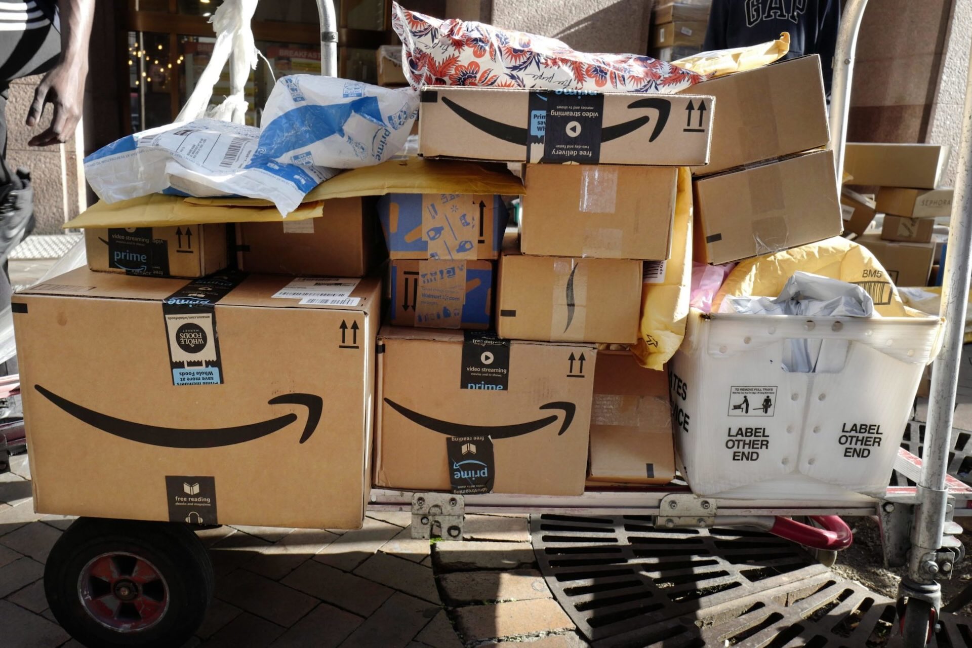 A utility cart stacked high with parcels bearing Amazon's logo.
