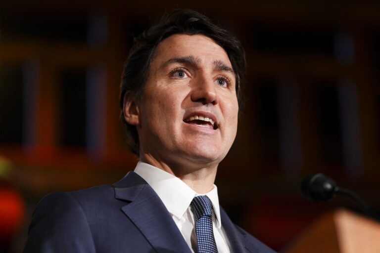 A close-up of Justin Trudeau in mid-sentence. He's wearing a blue suit jacket and blue tie.