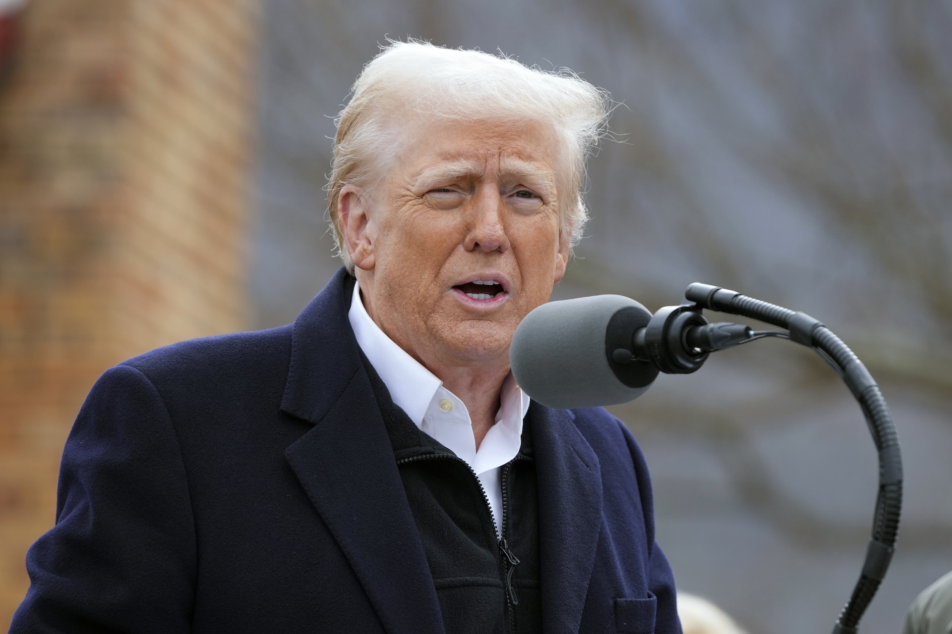U.S. President Donald Trump speaking into a microphone.