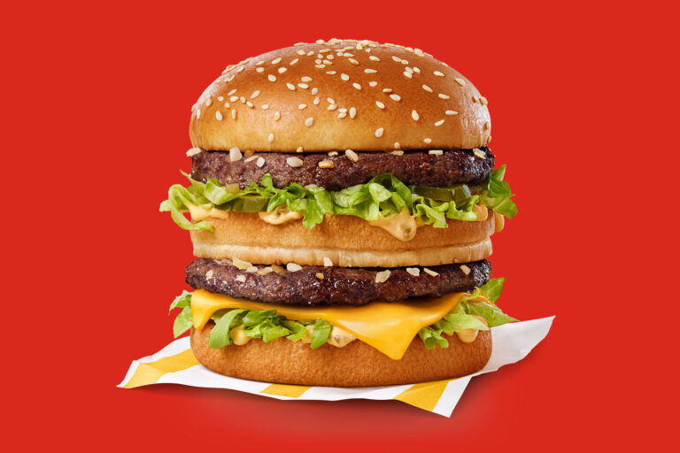 An image of a Big Mac hamburger in front a red background.