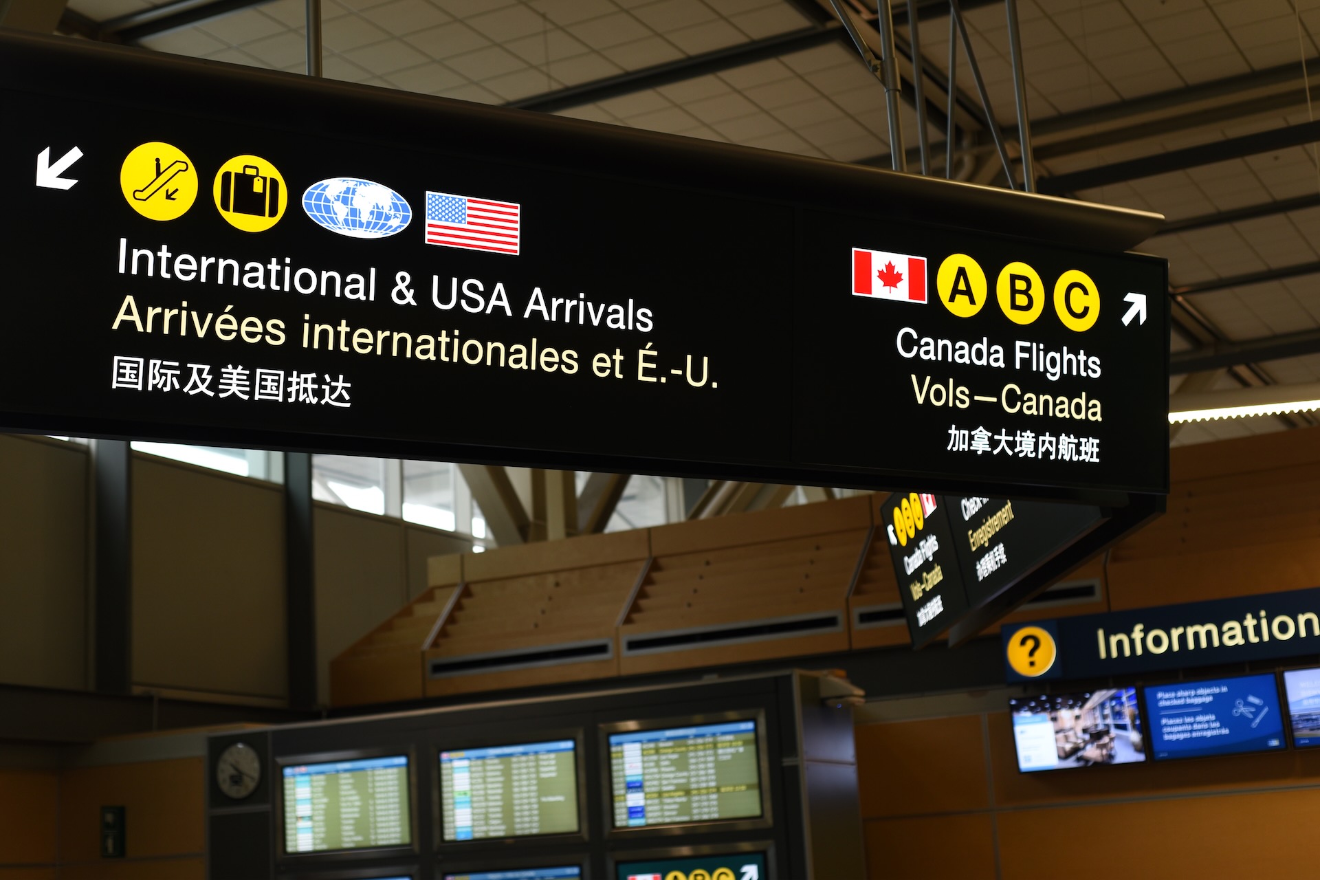 Directional signs for International & USA arrivals and for Canadian flights at Vancouver International Airport.