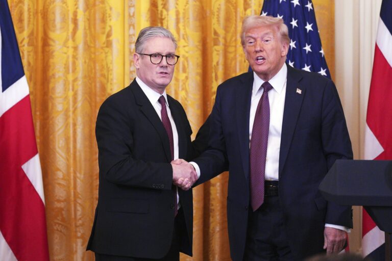 Britain's Prime Minister Keir Starmer and U.S. President Donald Trump shake hands with the British and American flags behind them.