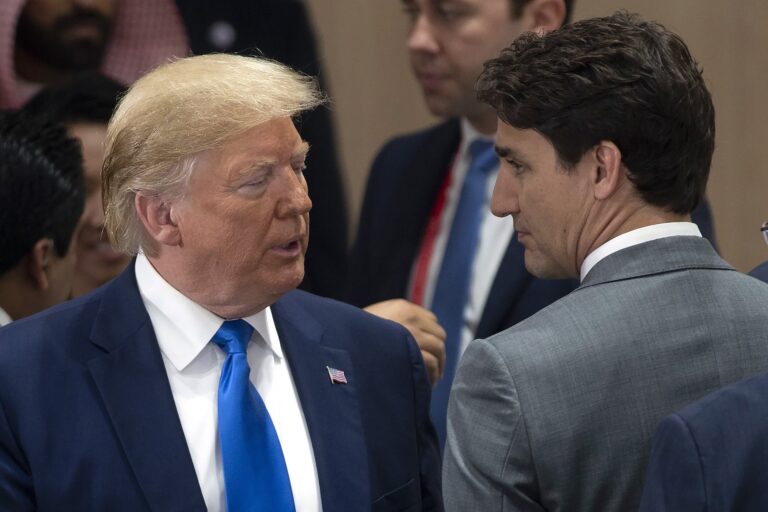 U.S. President Donald Trump and Canadian Prime Minister Justin Trudeau seen wearing suits and in mid-conversation.