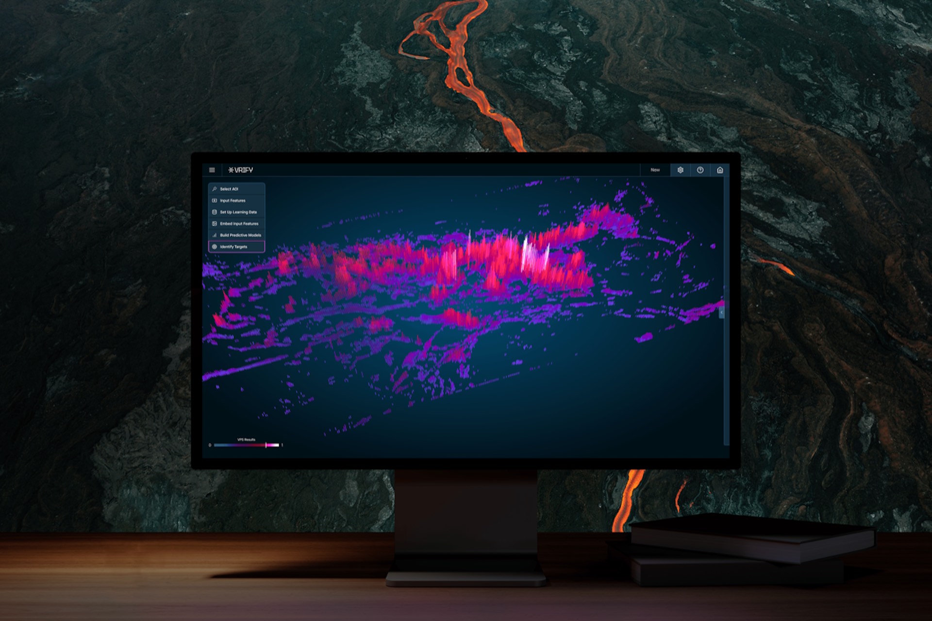 A monitor screen shows a rendering of a topographical map with pink and purple spikes on a black background. Behind the monitor is a backdrop of a stone wall.