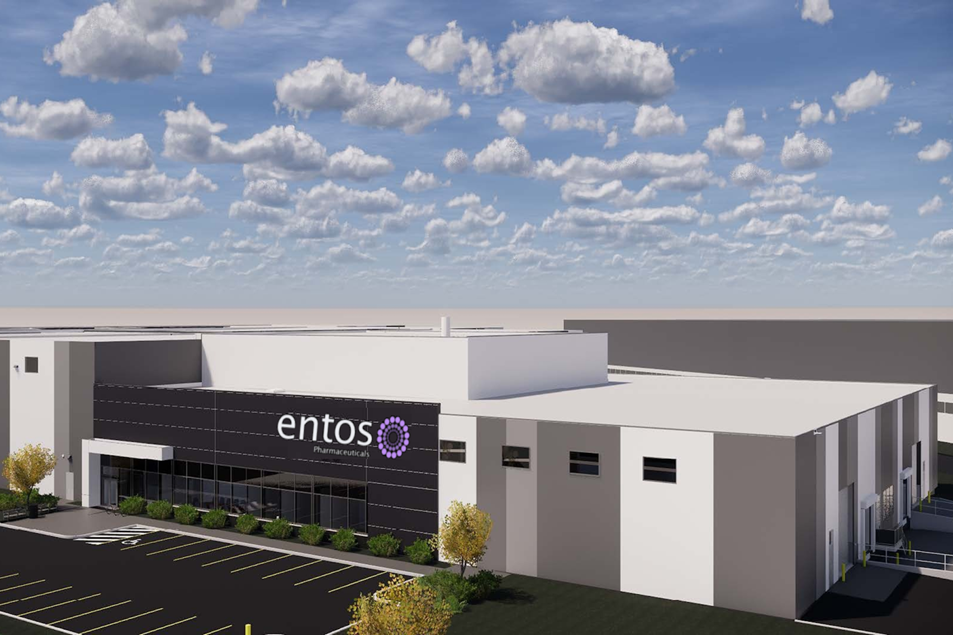A computer rendering of a boxy, white-and-grey light industrial building. The Entos logo appears on the dark glass facade around the front entrance.