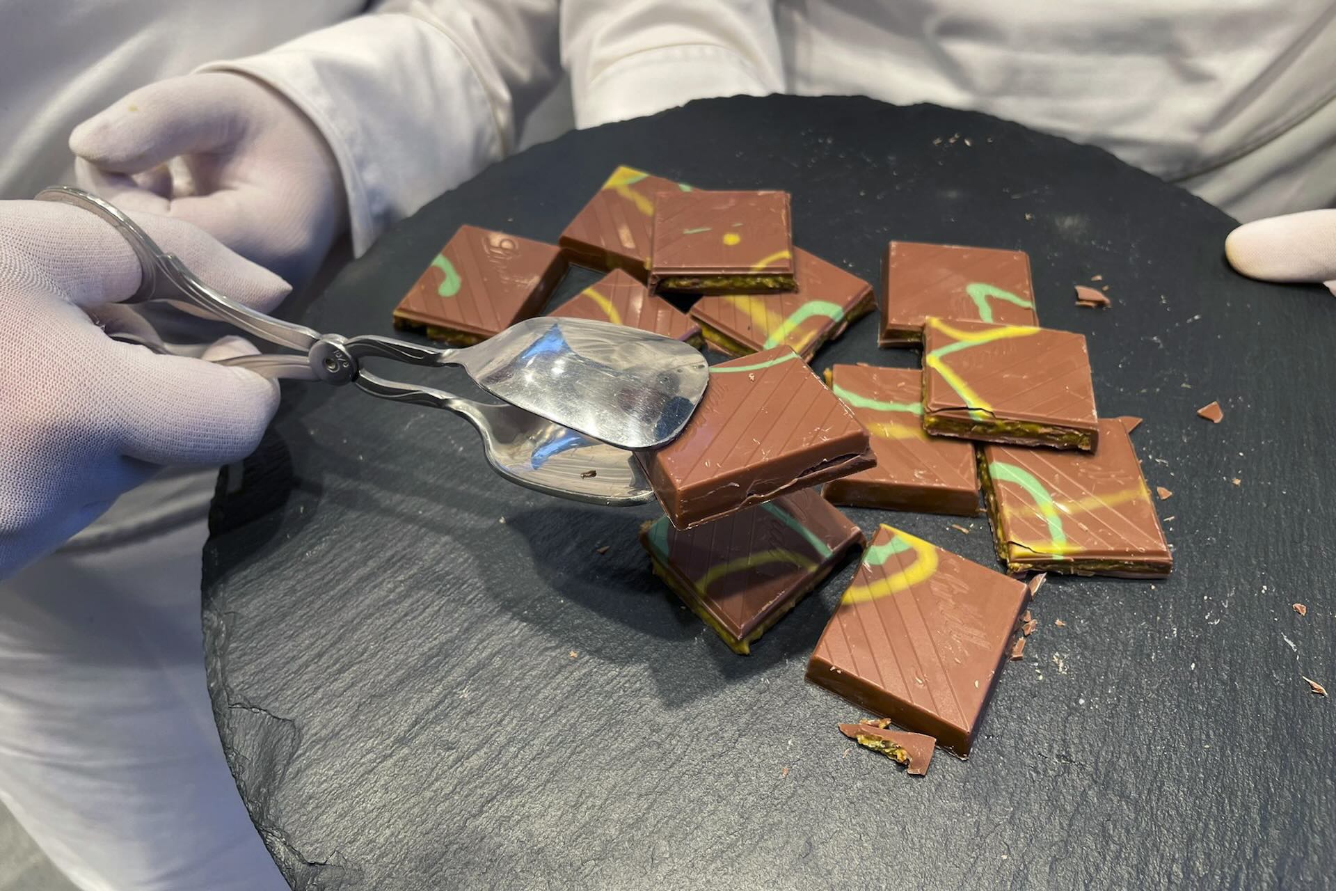 Silver prongs hold up a pile of Lindt chocolate atop a black table.