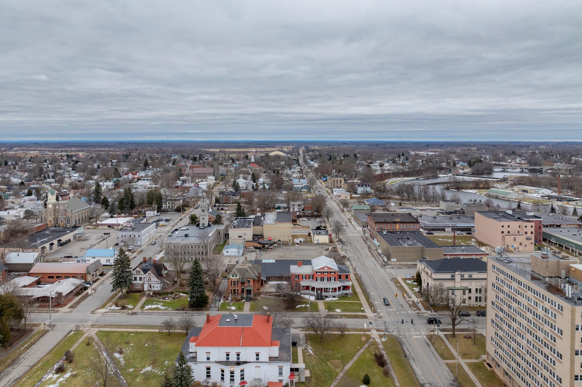 An aerial shot of an upstate New York city against a flat, grey sky.