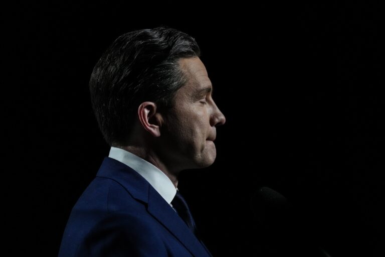 A head-and-shoulders profile shot of Pierre Poilievre, with lips creased and eyes shut, against a black backdrop.