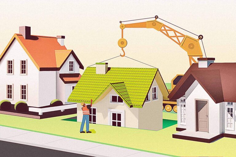 A construction worker guides a crane lifting the roof off a house between two other houses in a suburban neighborhood.