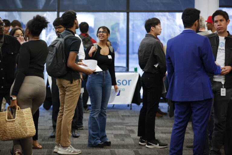 A queue of college students stand in line to speak with representatives of local tech companies during a job fair on Wednesday, March 29, 2023, in Atlanta.