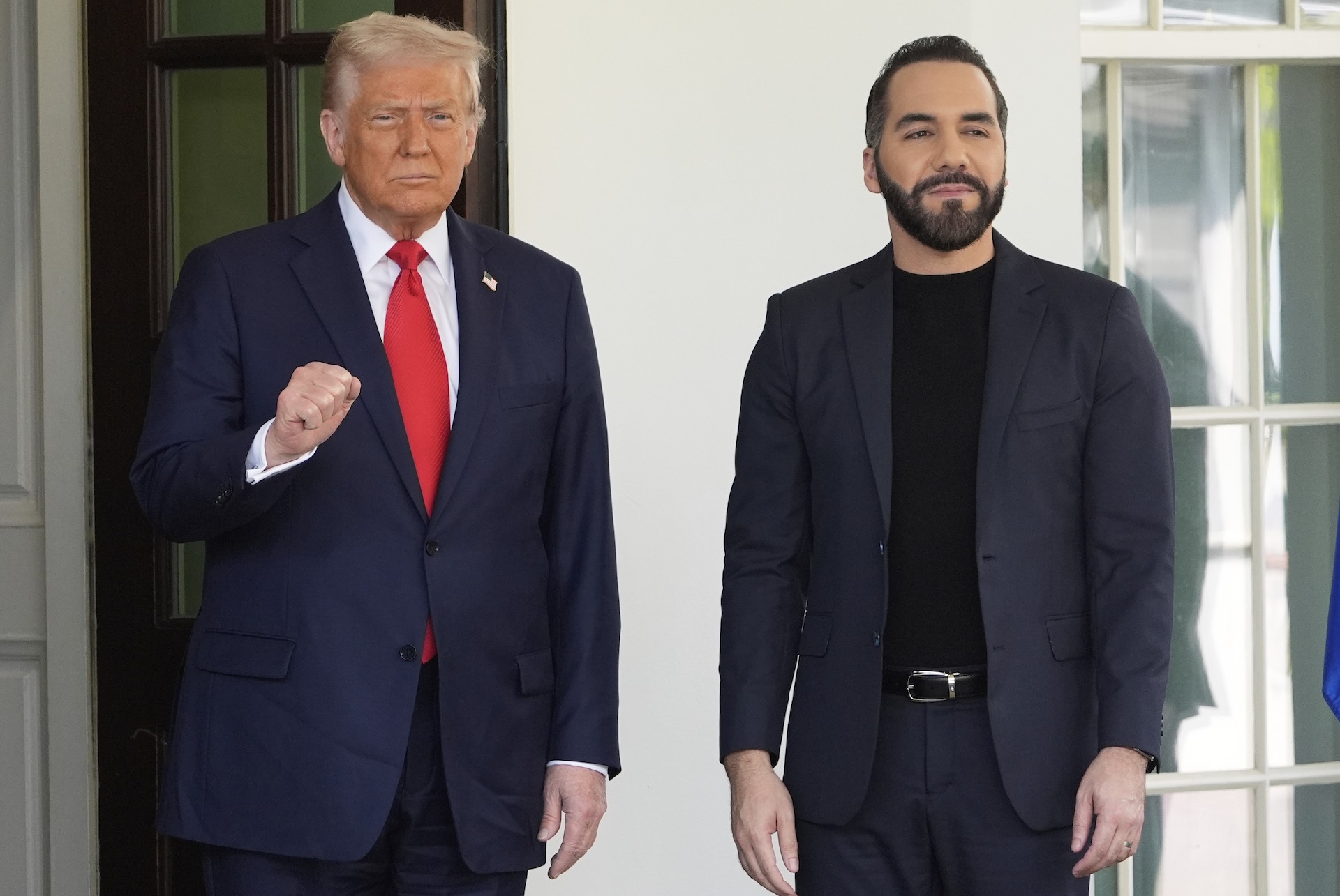 This photo shows U.S. President Donald Trump greeting El Salvador's president, Nayib Bukele, outside the White House. Trump has his right fist slightly raised in what appears a celebratory gesture.