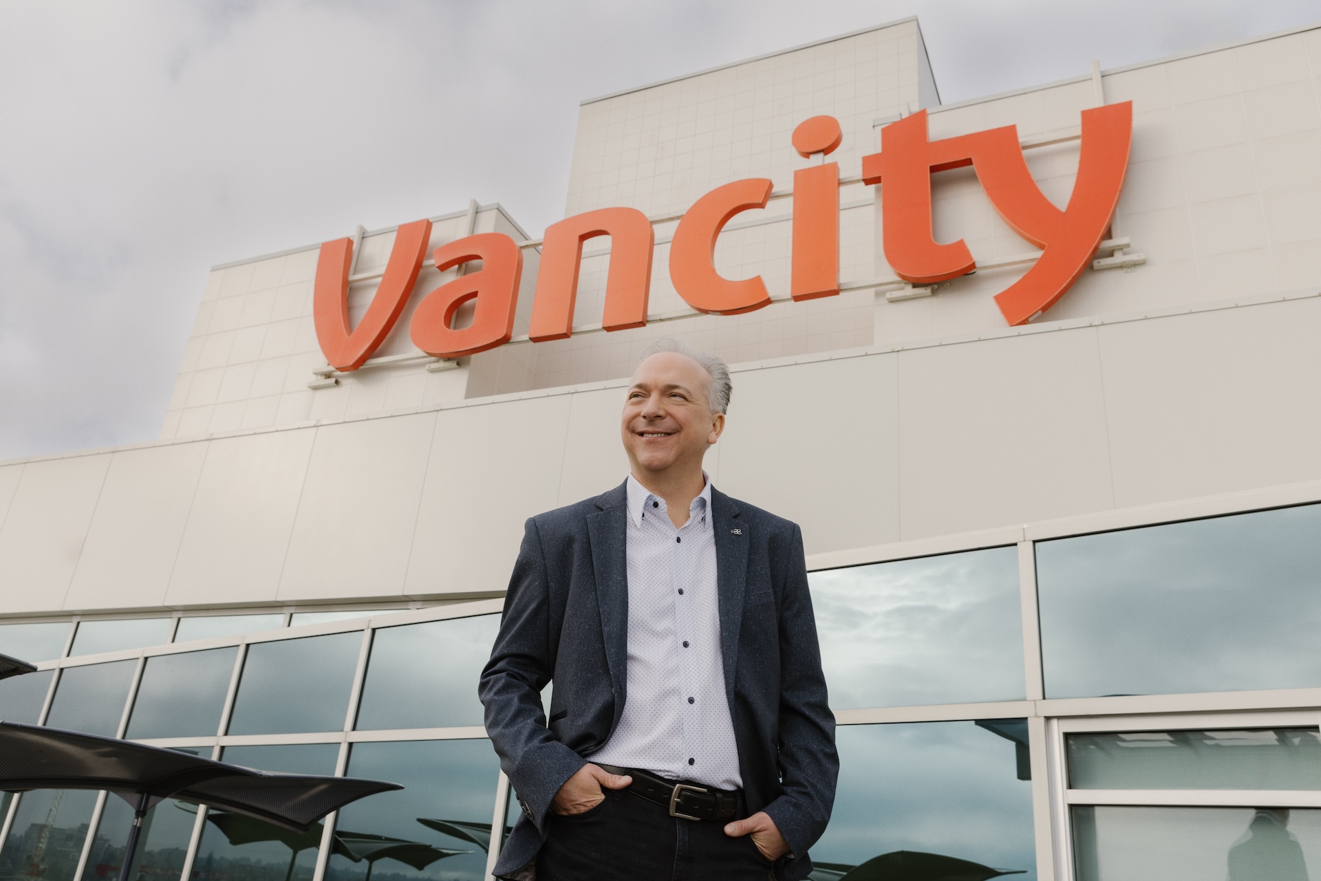 Vancity CEO Wellington Holbrook stands in front of the building bearing the credit union’s logo.