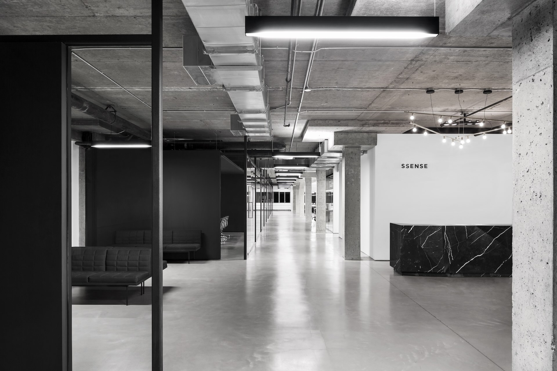 A black-and-white image of an empty office space with the word "Ssense" visible on one wall.