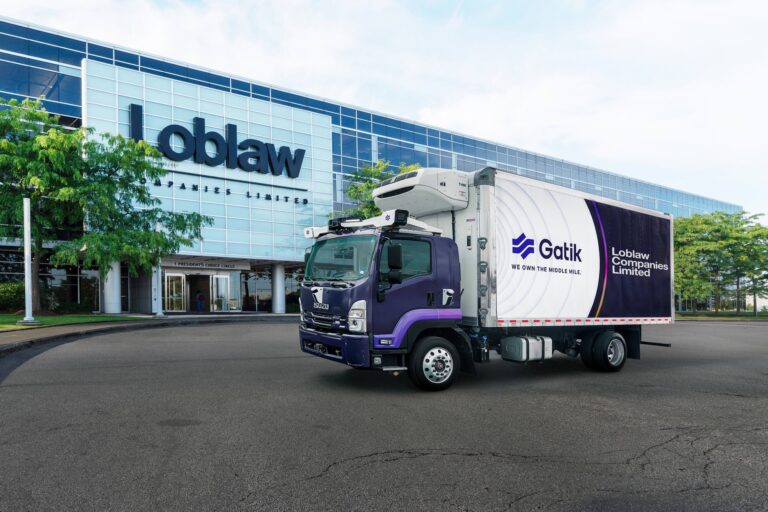 A daytime shot of one of Gatik's purple, cube van-style trucks in front of Loblaw headquarters in Brampton, Ontario.