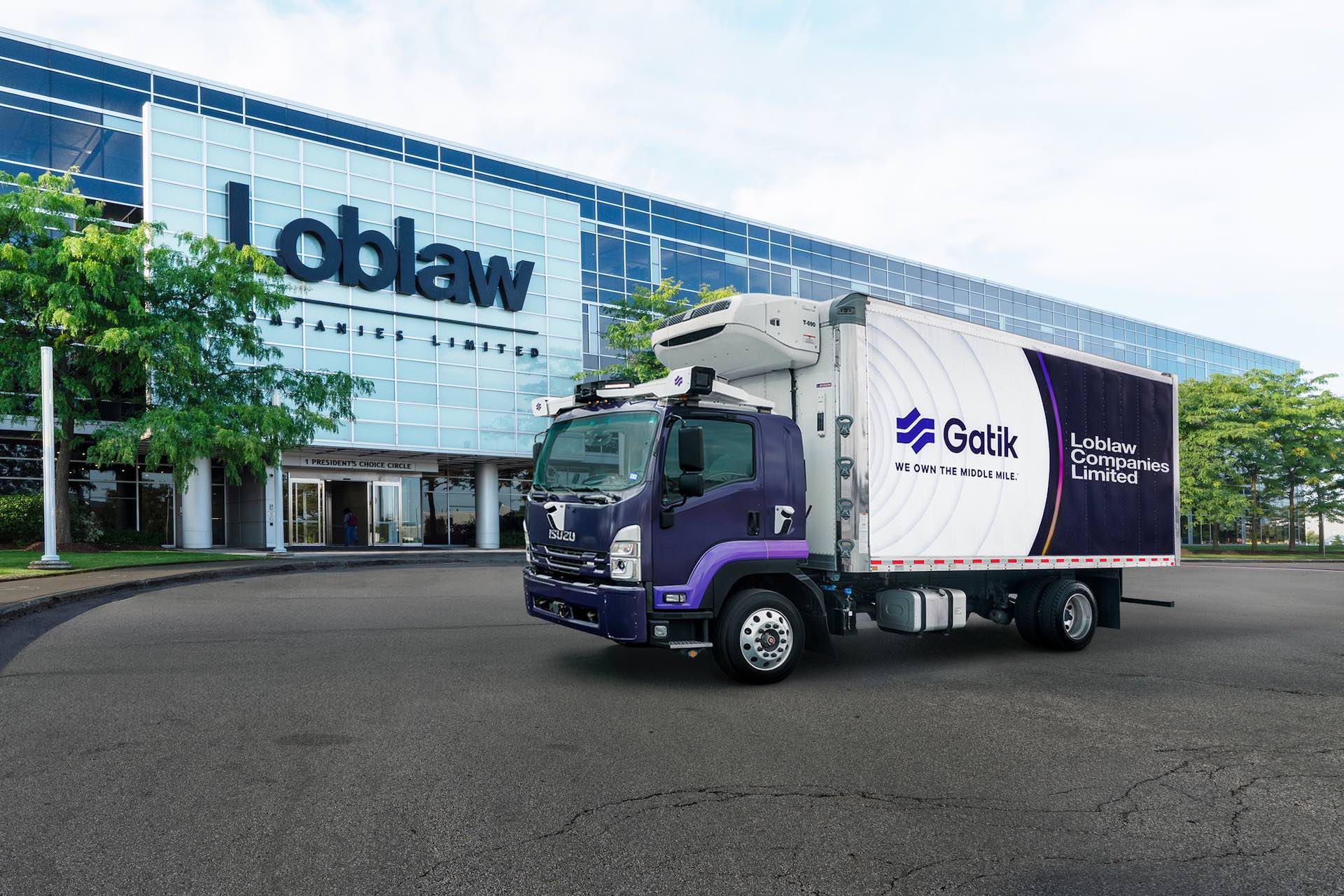 A daytime shot of one of Gatik's purple, cube van-style trucks in front of Loblaw headquarters in Brampton, Ontario.