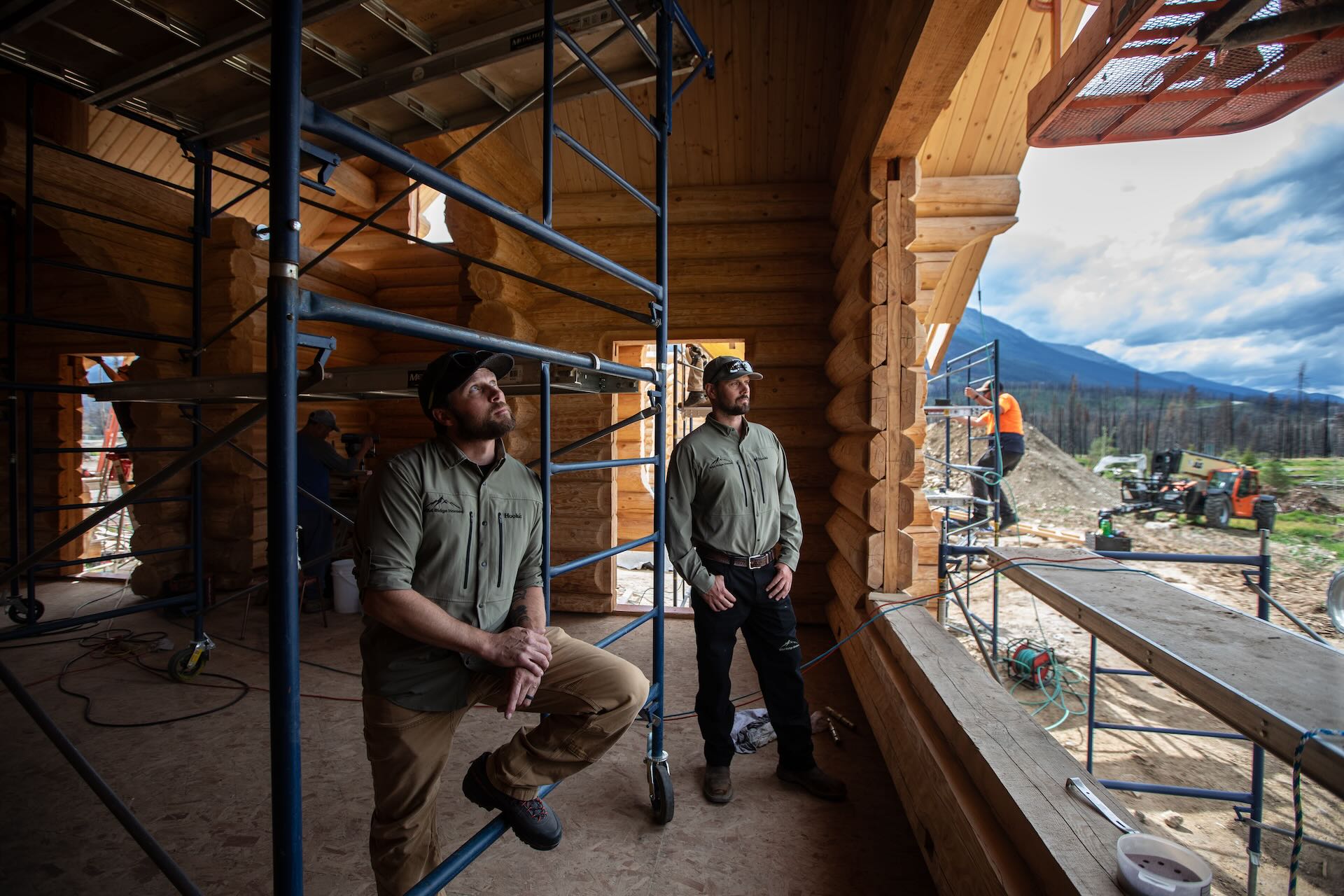 Two men inside a construction unit look over a construction site at Alpine Village.