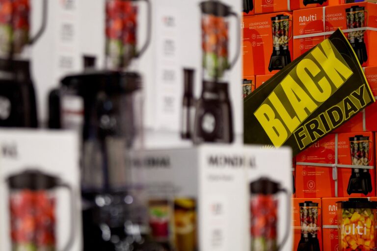Several stacks of blenders in retail packaging with a "Black Friday" sign stuck to the side of one stack.