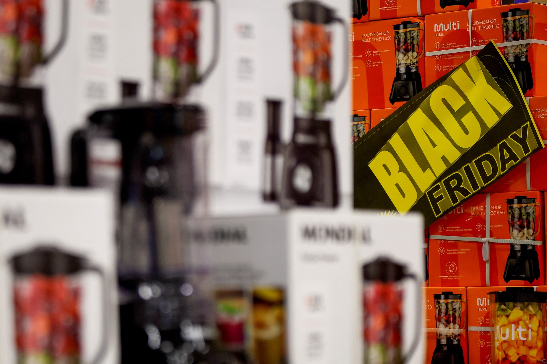 Several stacks of blenders in retail packaging with a "Black Friday" sign stuck to the side of one stack.
