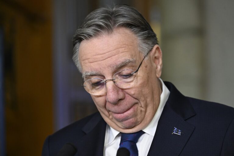 Image of François Legault looking downward, lips tight