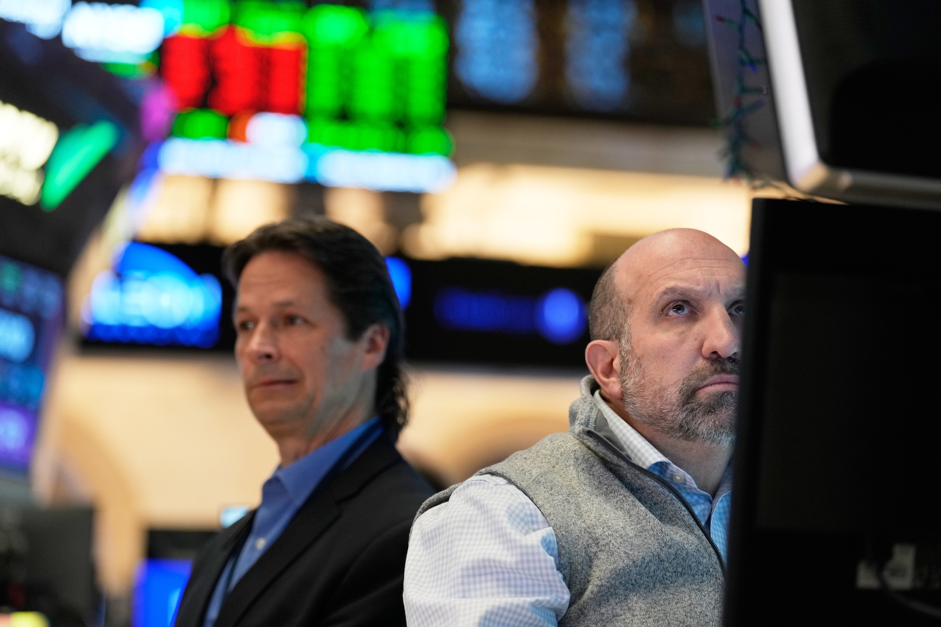 Two men work on the floor at the New York Stock Exchange.