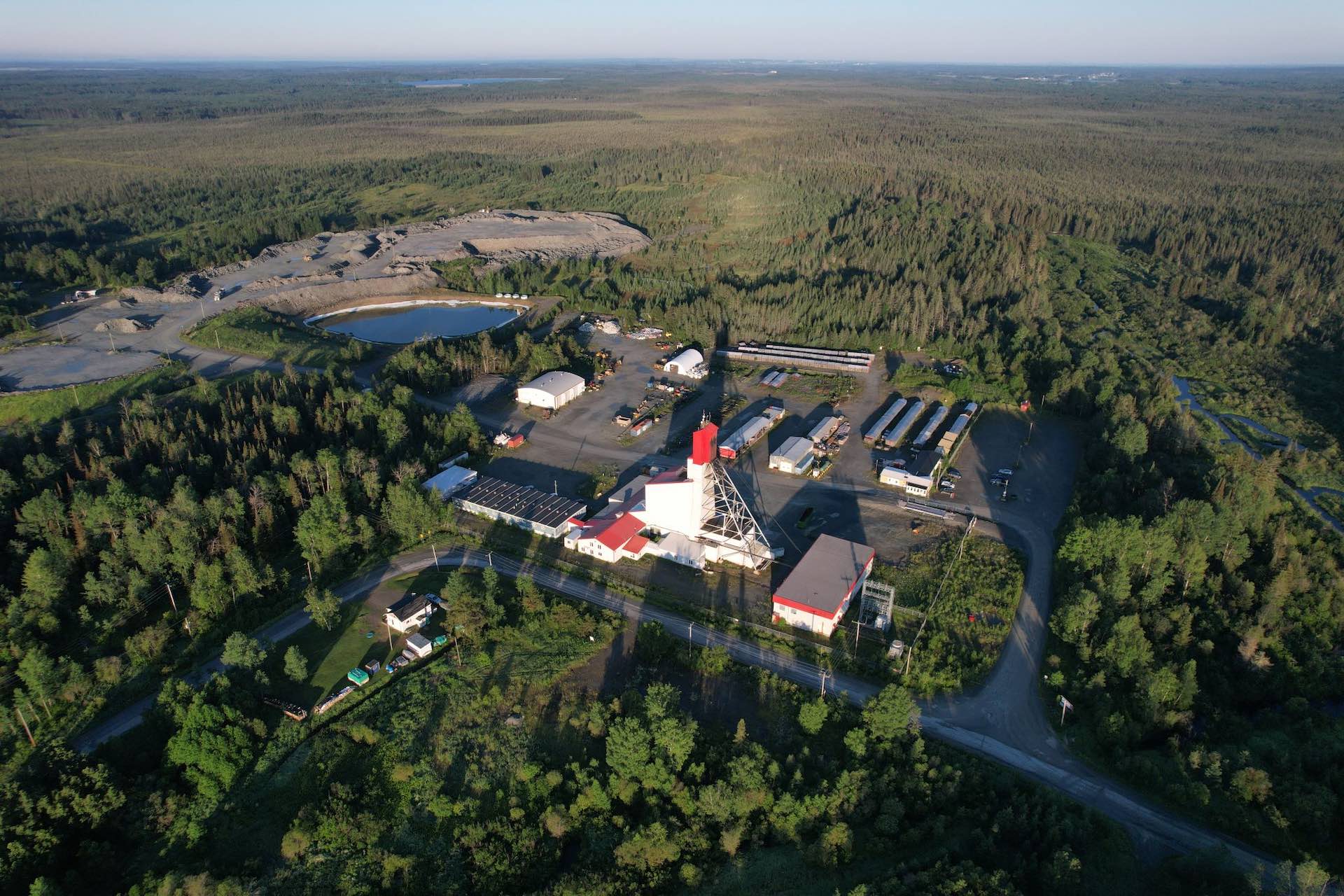 An aerial shot of a mine site in an expanse of of forest and lakes.