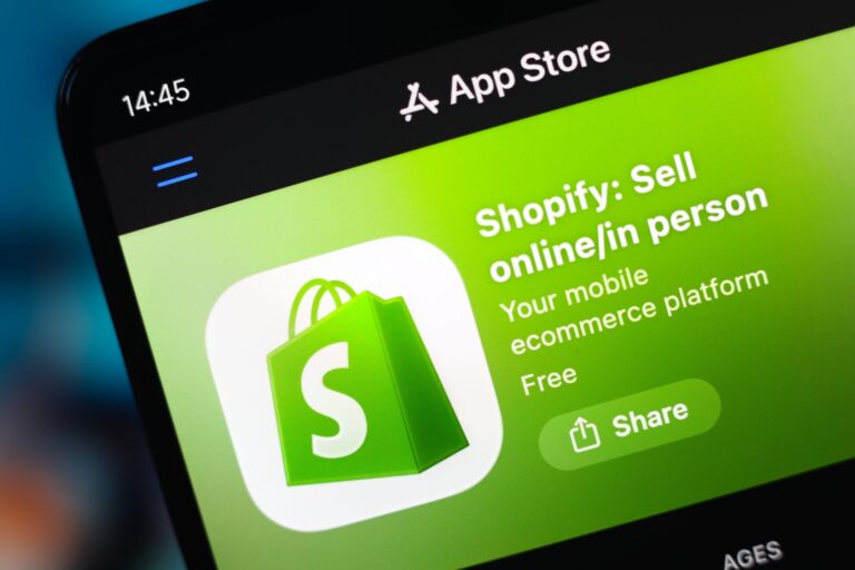 The Shopify logo and the text "Shopify: Sell online/in person" appear on an App Store screen on a smartphone screen.