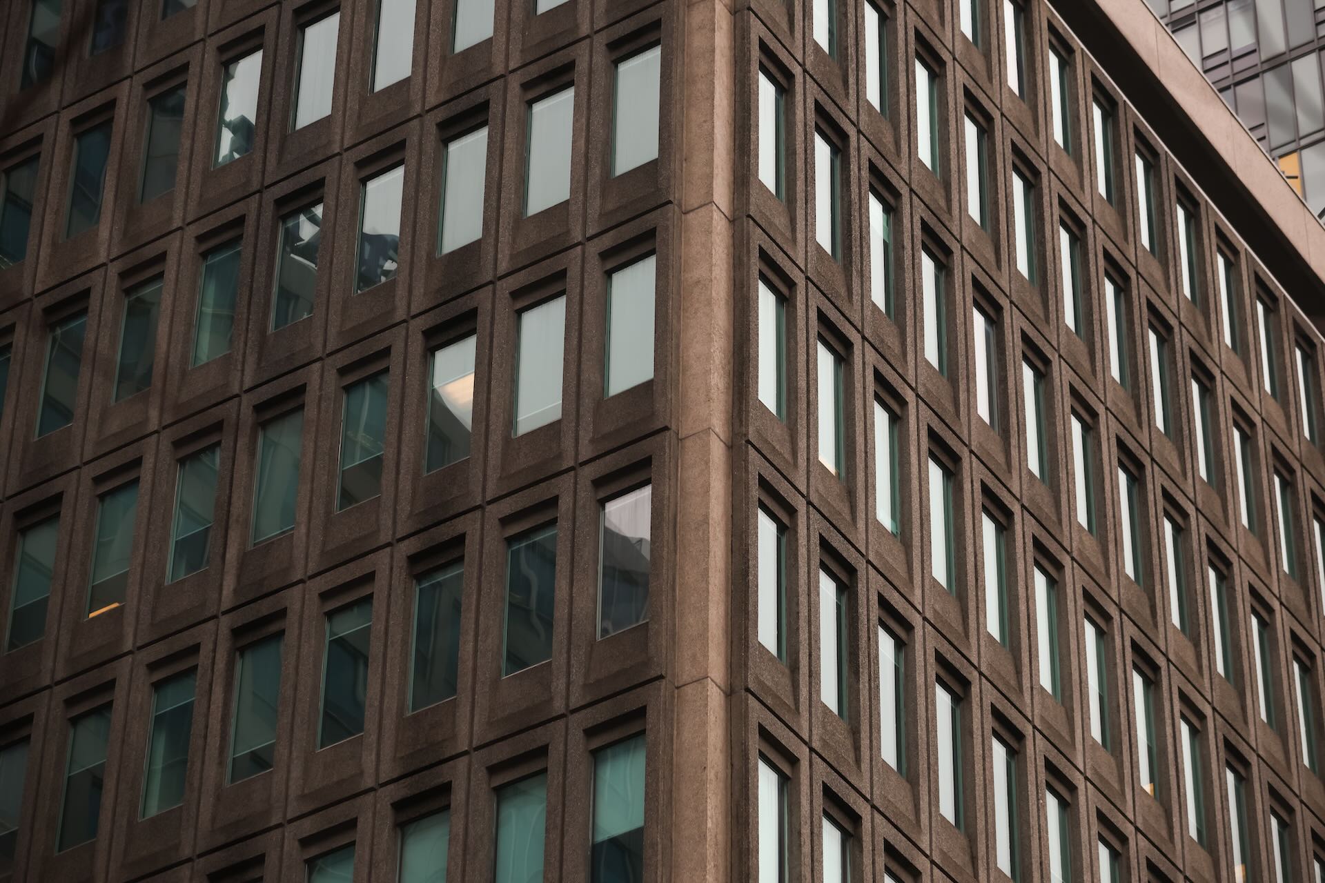 The dark stone exterior and glass windows of an office building in Toronto fill the frame.
