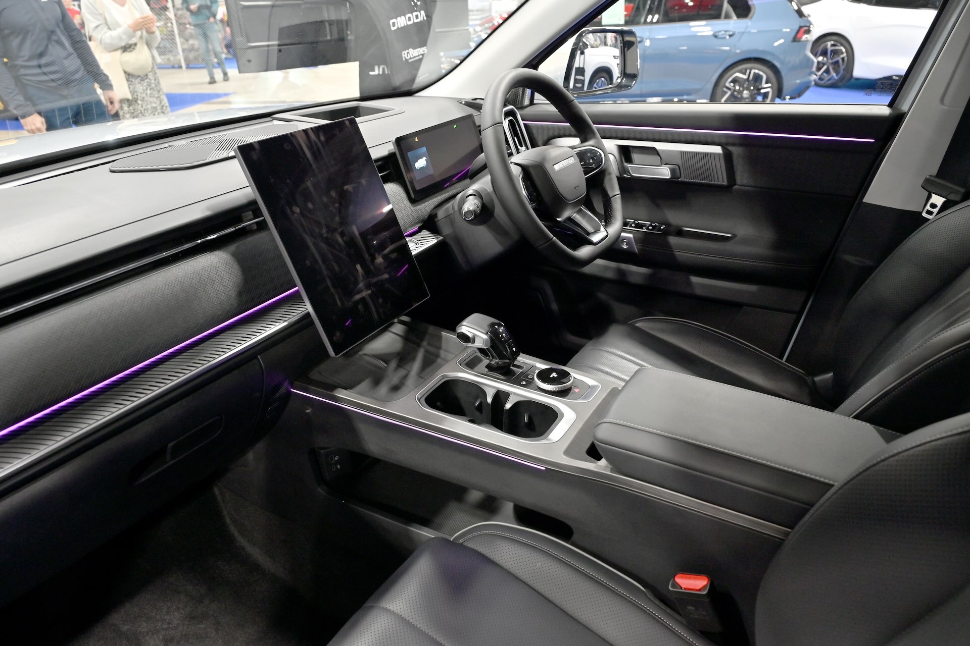 The image shows the interior of a Jaecoo 7 vehicle. The steering wheel is on the right-hand side, with a large screen visible to its left.