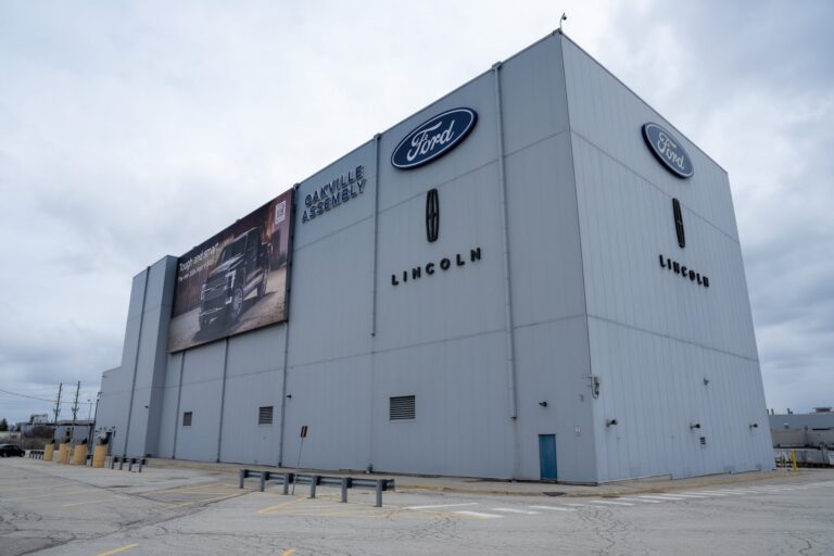 A shot of a tall building in a Ford auto assembly complex, surrounded by an empty parking lot.