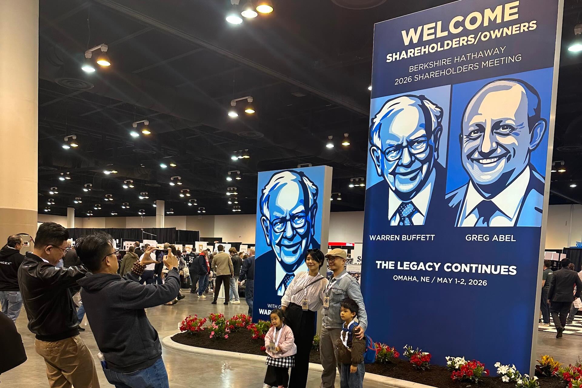 Shareholders line up to take pictures with depictions of Berkshire Hathaway's new CEO Greg Abel and Chairman Warren Buffett on Friday, May 1, 2026 in Omaha, Neb.